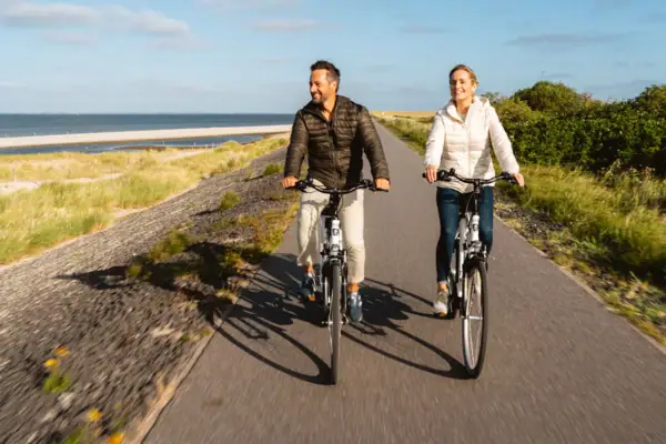 Ein Mann und eine Frau fahren auf einer Straße Fahrrad.