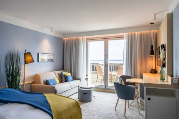 Ein modernes Hotelzimmer mit einem Bett und einem Sofa.