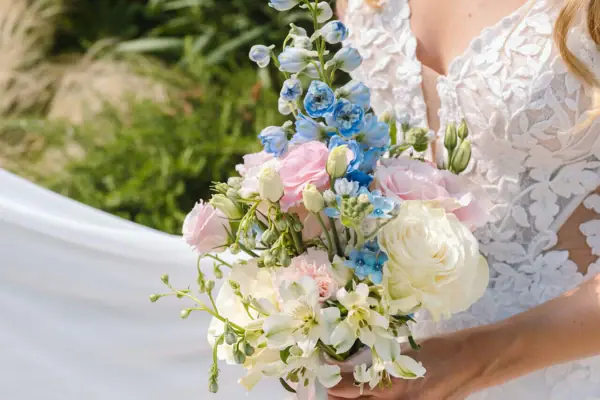A woman in a white dress is holding a bouquet of flowers.