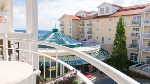 View from a balcony of a large yellow hotel building with a glass dome.