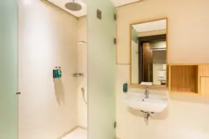 A bathroom with shower and washbasin.