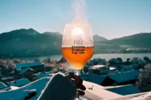 A hand is holding a glass of wine, from which smoke is rising.
