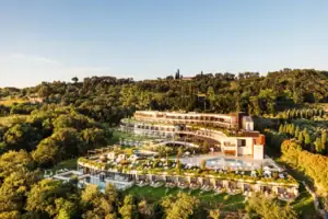 A building with a swimming pool, surrounded by trees.