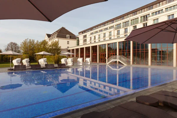 A view of an outdoor pool area of a hotel with beach chairs on a quiet morning. 