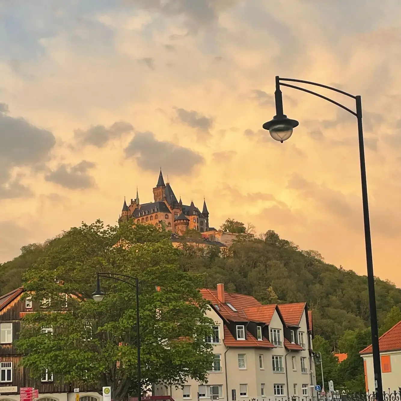 A building on a hill with trees in the background.