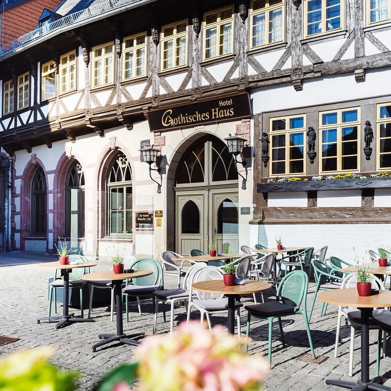 A-ROSA Gothic House A building with tables and chairs outside.