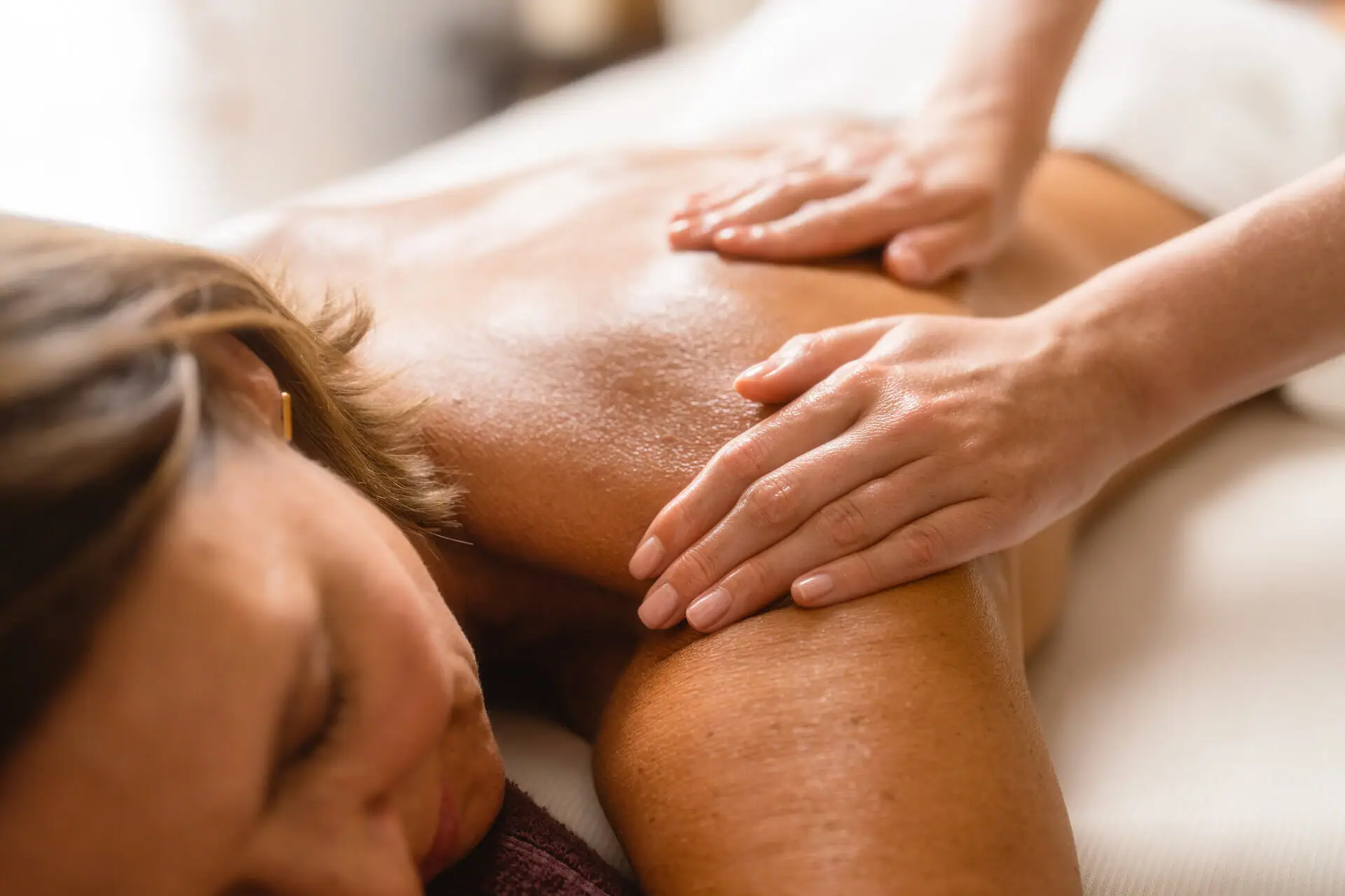 A woman receiving a back massage indoors.