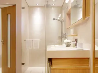 A bright bathroom with a shower and washbasin.