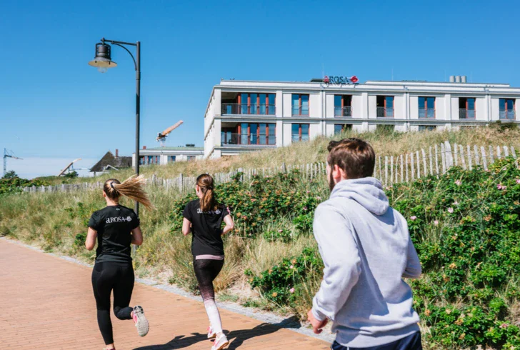 A group of people running on a brick path outdoors.