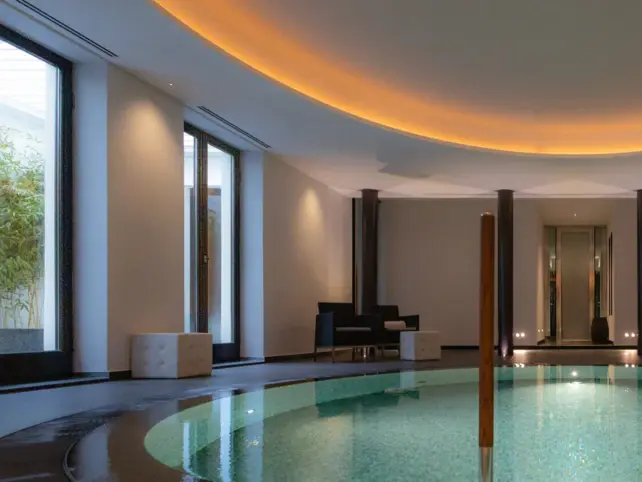 Indoor swimming pool with elegant lighting and modern design in a hotel setting.