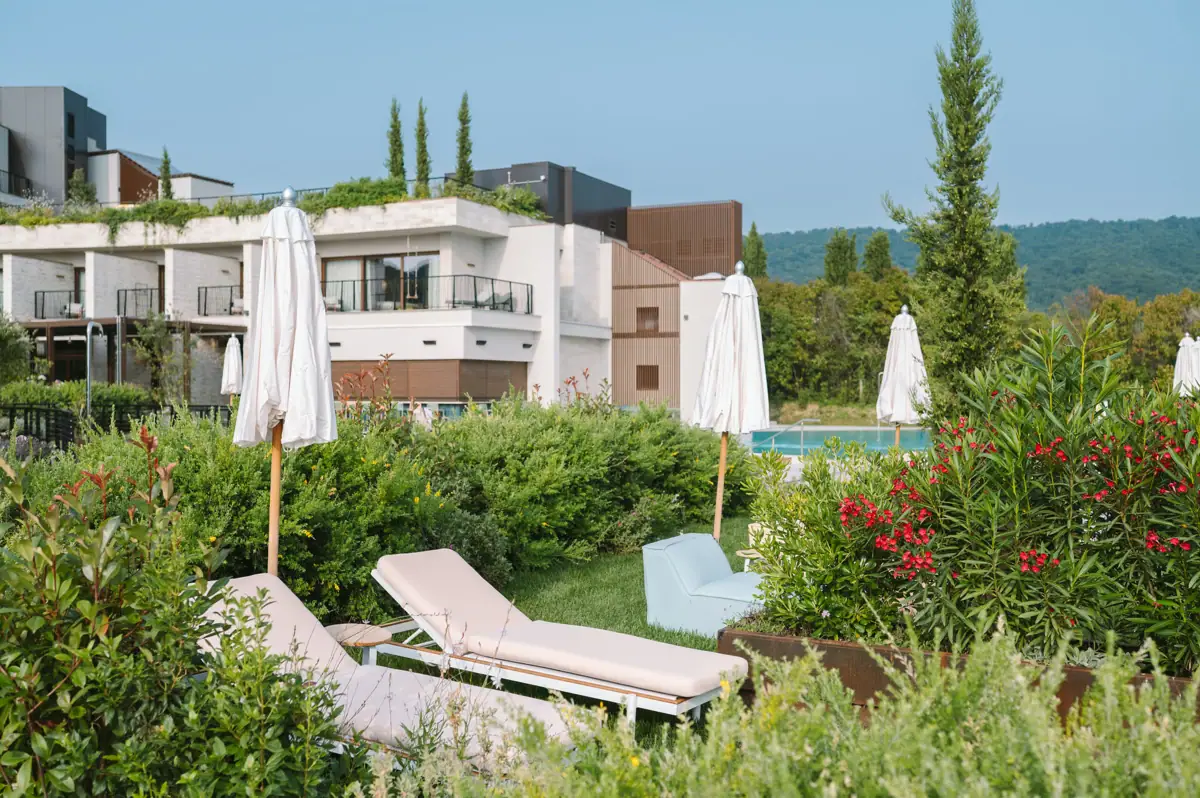 Liegestühle und Sonnenschirme in einem Garten.