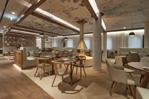 The Freyheit restaurant at A-ROSA Tegernsee, with tables laid for dining.