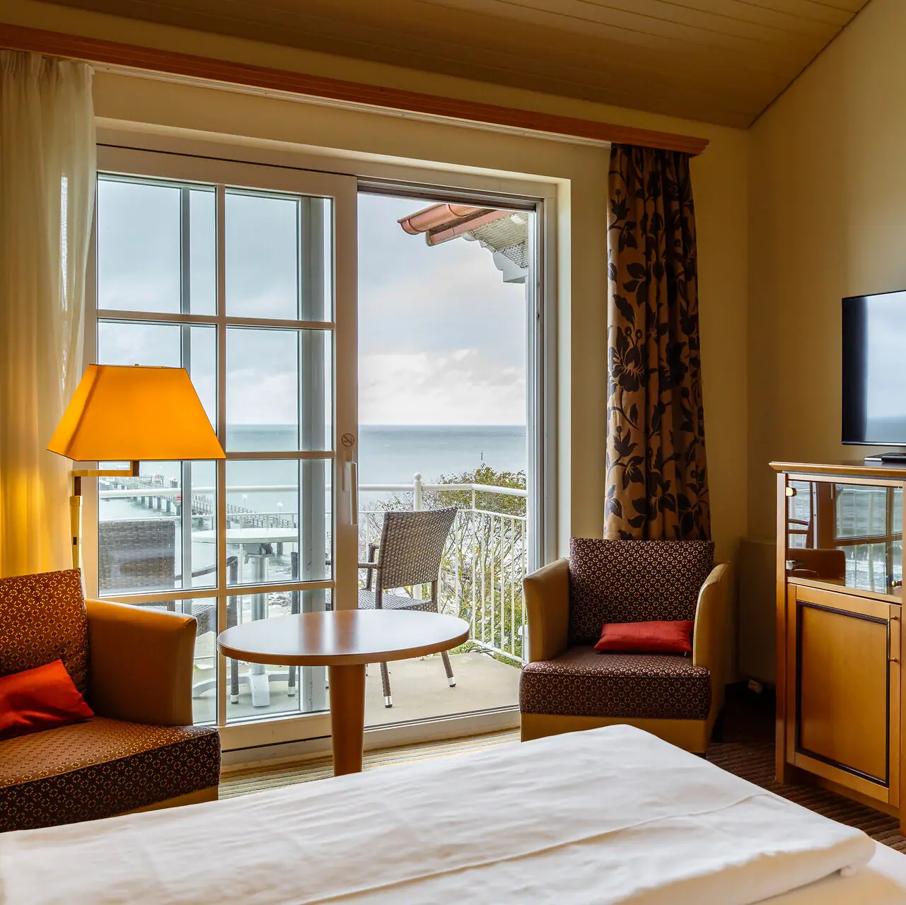 A hotel room with a television and a table.