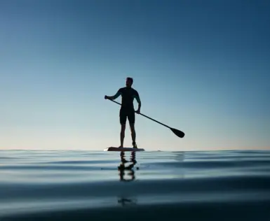 Man on a stand-up paddleboard on the water.