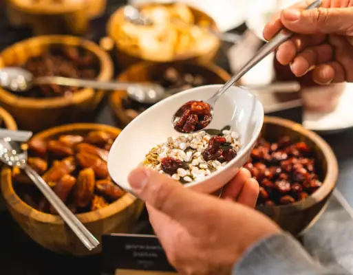 A person holding a bowl of food indoors.