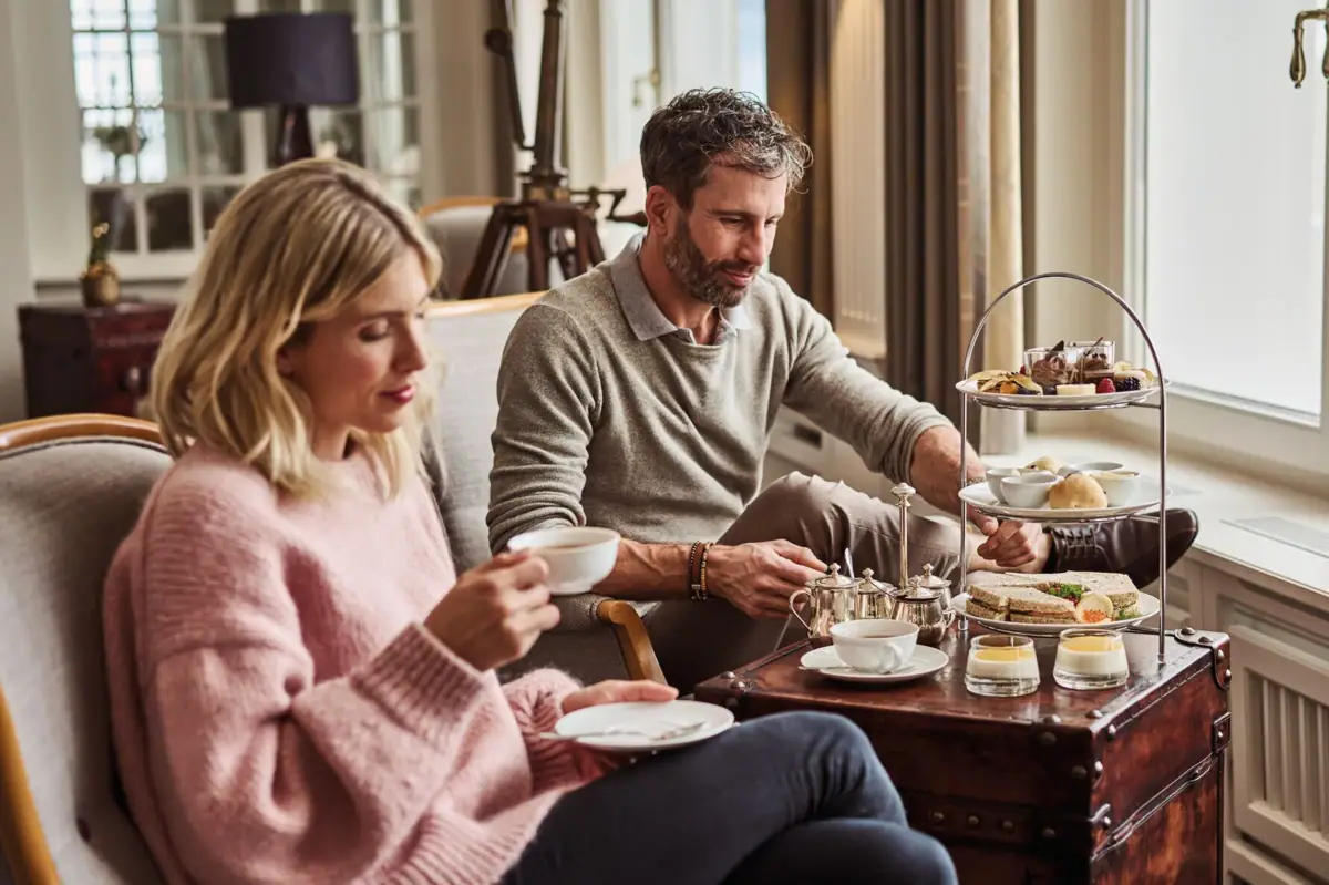 A man and woman sitting at a table with food.