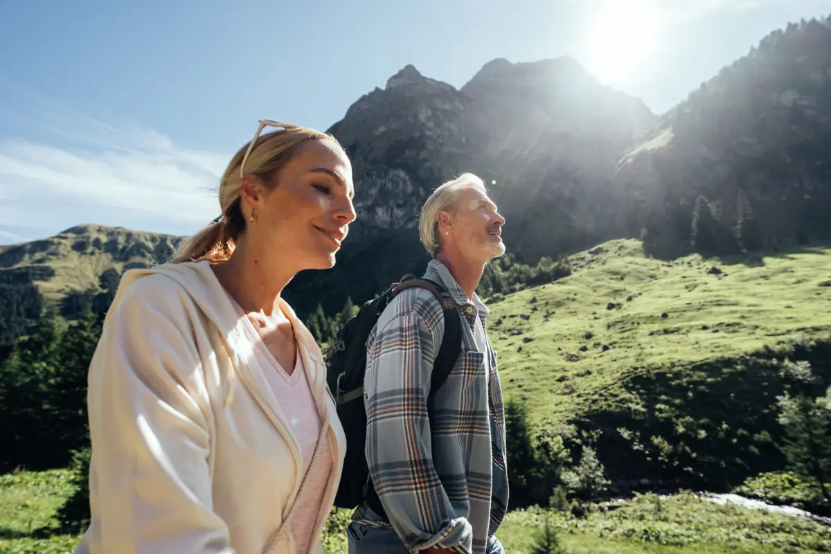 A man and a woman are standing in a grassy area.