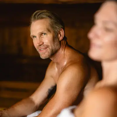 A man and a woman sit smiling in a room.