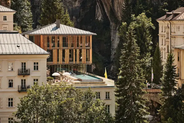 Building with pool in the middle of a ravine, surrounded by trees.