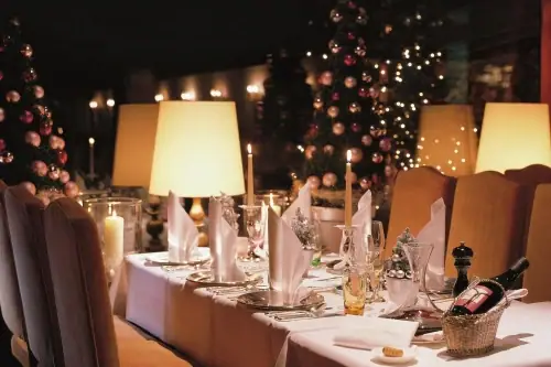 Ein für eine Dinnerparty gedeckter Tisch mit Kerzen und Tischgeschirr.