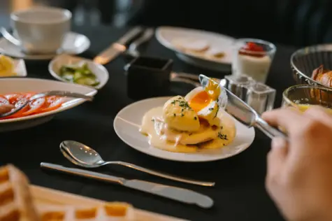 A poached egg which is cut open by a knife. 