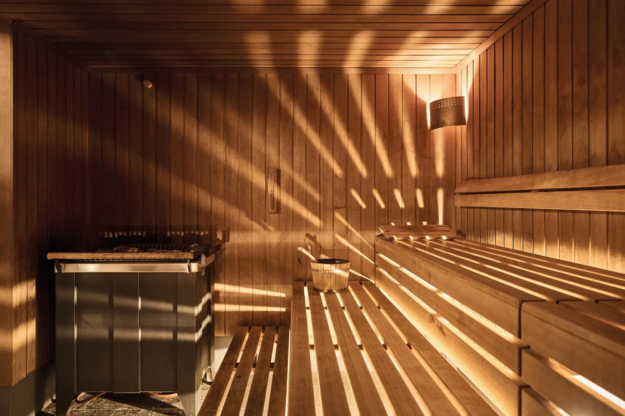 Holzsauna mit Sonnenlicht, das durch die Wände scheint