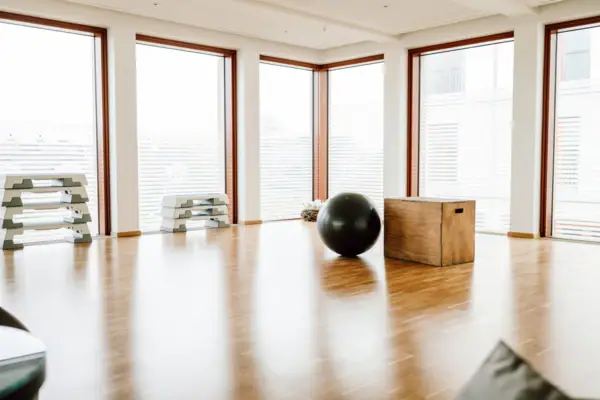 Trainingsraum Großer schwarzer Ball auf einem Holzboden in einem Raum mit Fenstern.