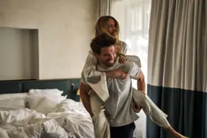 A man is carrying a woman on his shoulders.