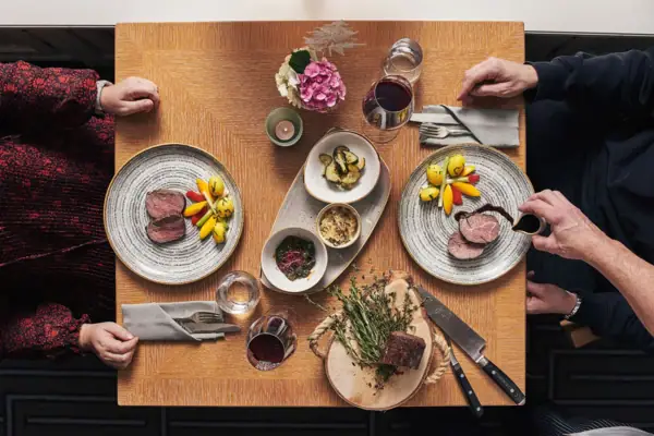 A group of people sitting at a table with plates of food.