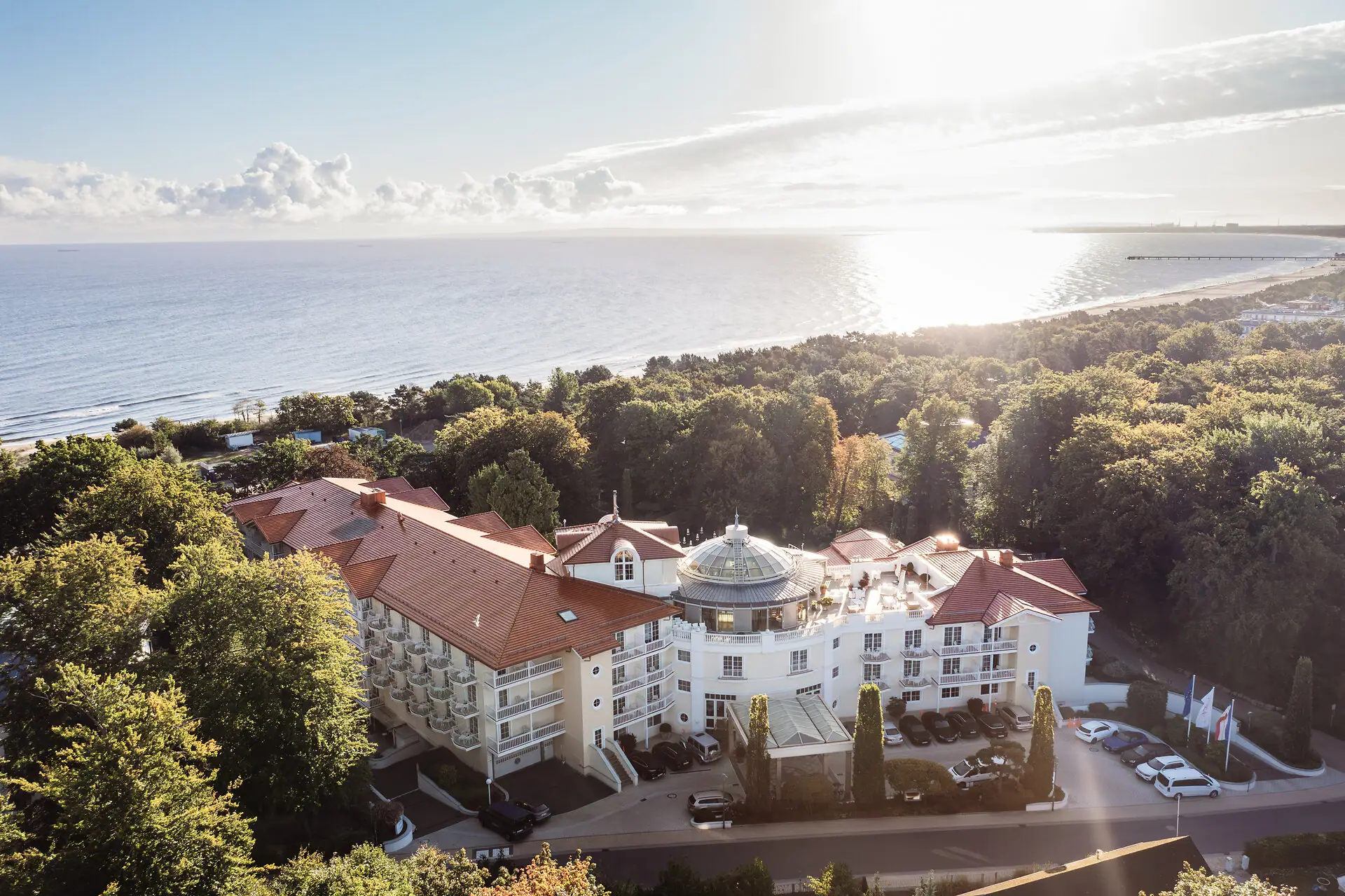 A-ROSA Heringsdorf Large building with trees and a body of water in the foreground.