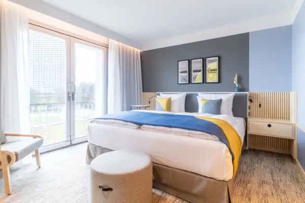 A bed in a hotel room with elegant bed linen and pillows.