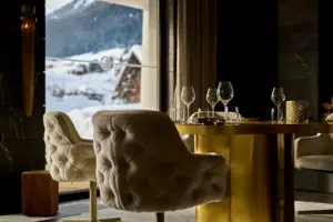 A table with wine glasses and a view of a snow-capped mountain.