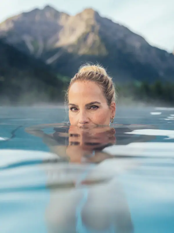 A woman in the outdoor pool at the A-ROSA Ifen Hotel Kleinwalsertal
