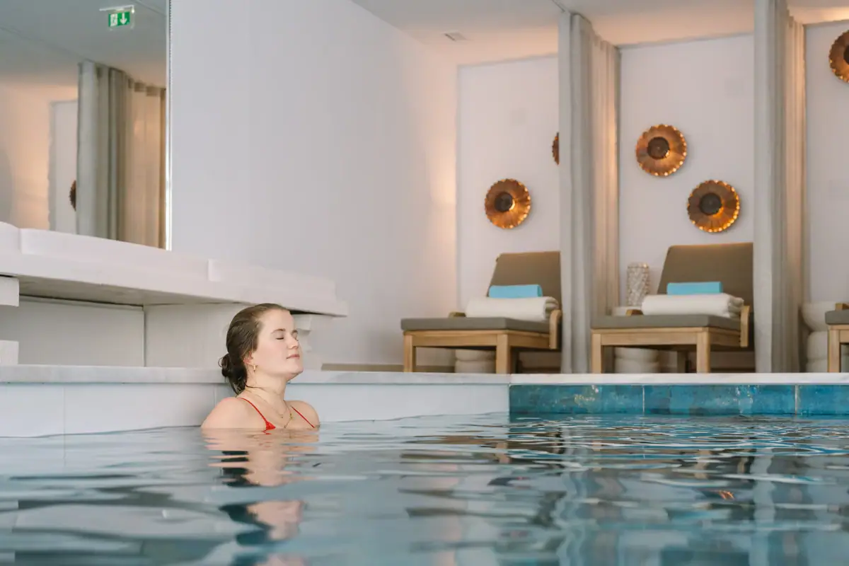 Eine Frau schwimmt in einem Hallenbad.