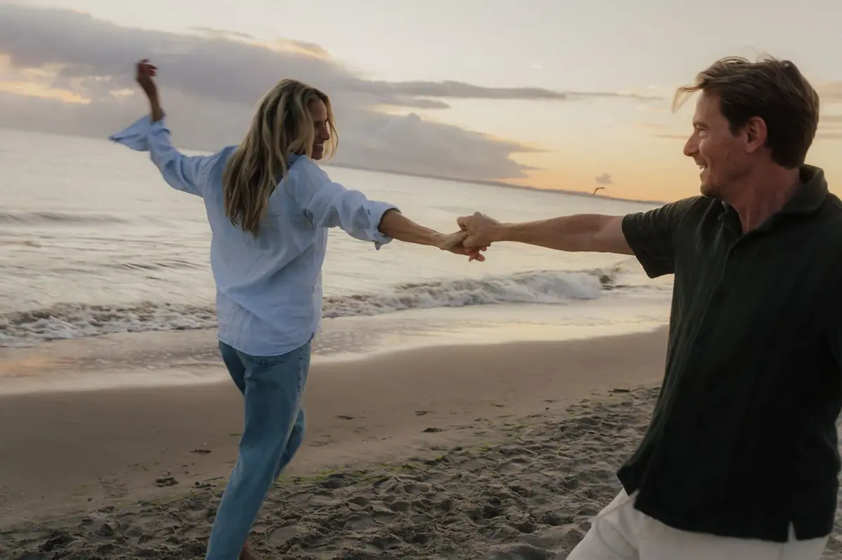 Couple on the beach A man and a woman hold hands on a beach.