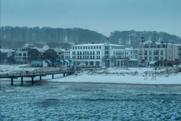 Schneebedeckter Strand mit Gebäuden im Winter.