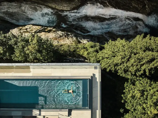 Person swims in an outdoor pool.