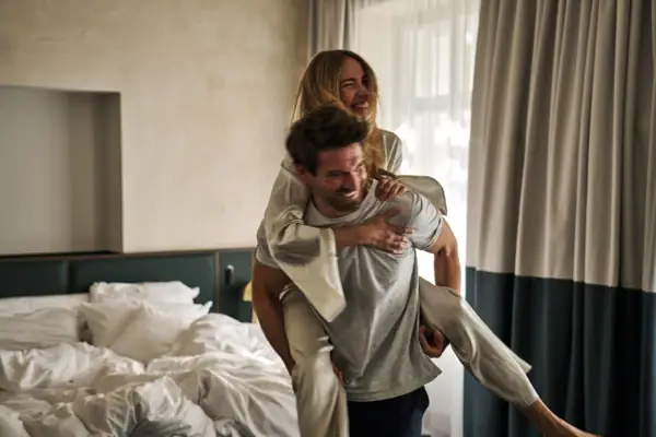 Happy couple in hotel room enjoying the early bird offer at Straubinger Grand Hotel Bad Gastein.