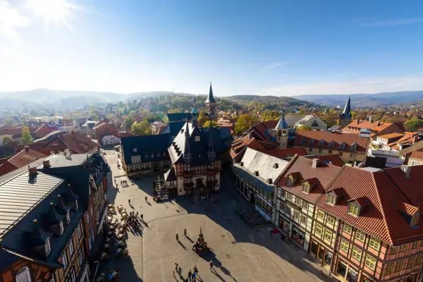 Gothisches Haus Wernigerode Ein Marklplatz mit vielen Fachwerk-Gebäuden unter einem blauen Himmel.