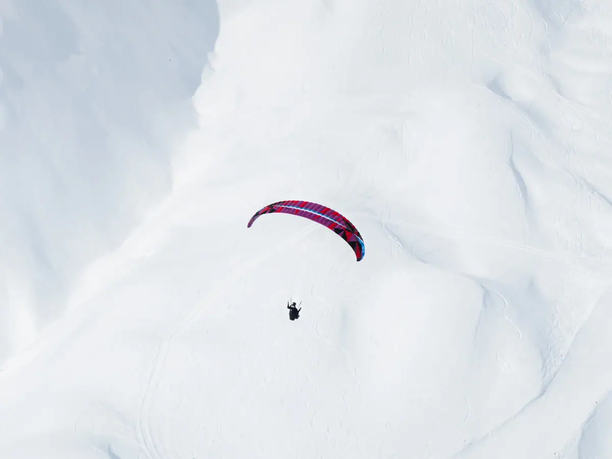 A person skydiving in the snow.