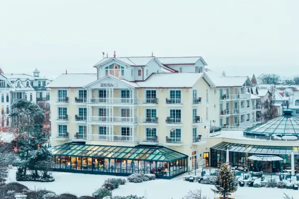 A building in the snow with trees in the background.