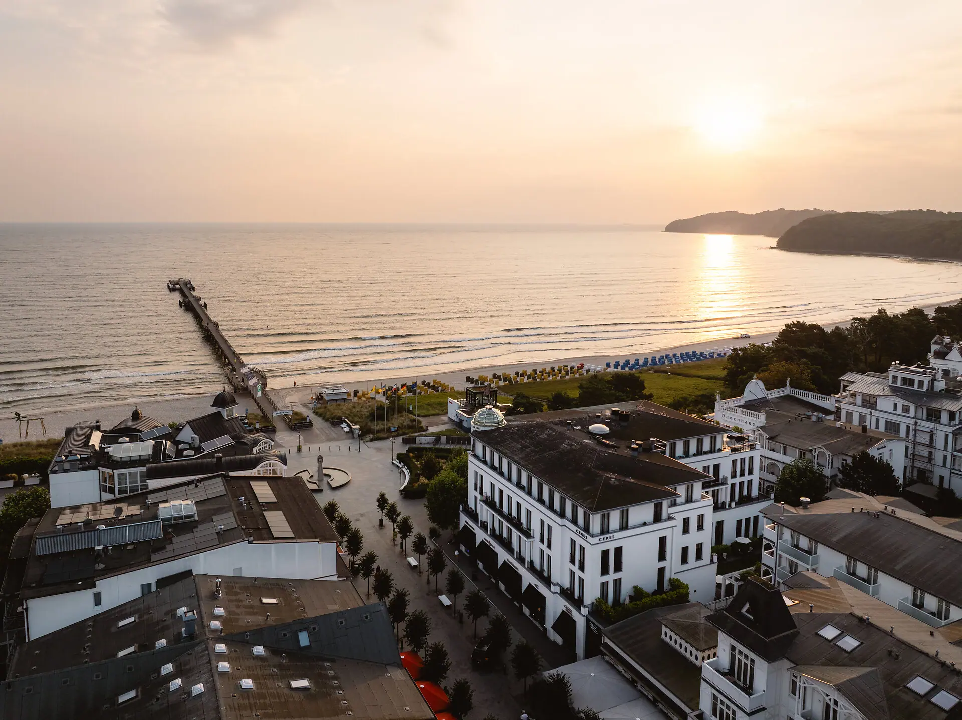 A beach with buildings and a pier.