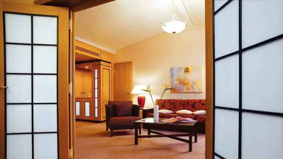 Living room with couch and coffee table, surrounded by a shoji wall design.