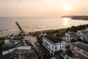 A beach with buildings and a pier in the background.