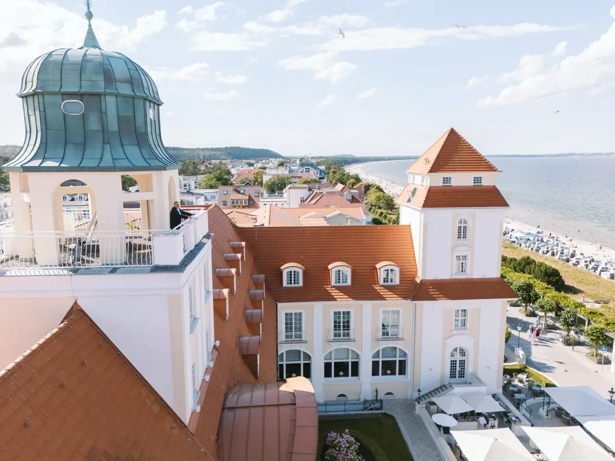 Kurhaus Binz Das Kurhaus Binz mit Glockenturm und Strand im Vordergrund.