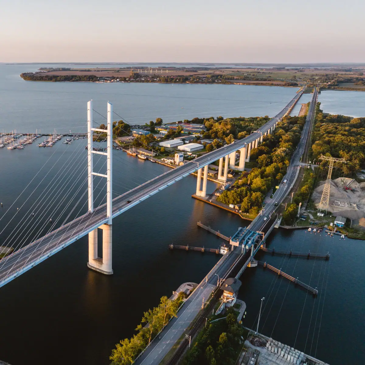 Die Rügenbrücke aus der Vogelperspektive mit Wasser, Booten und Rügen im Hintergrund
