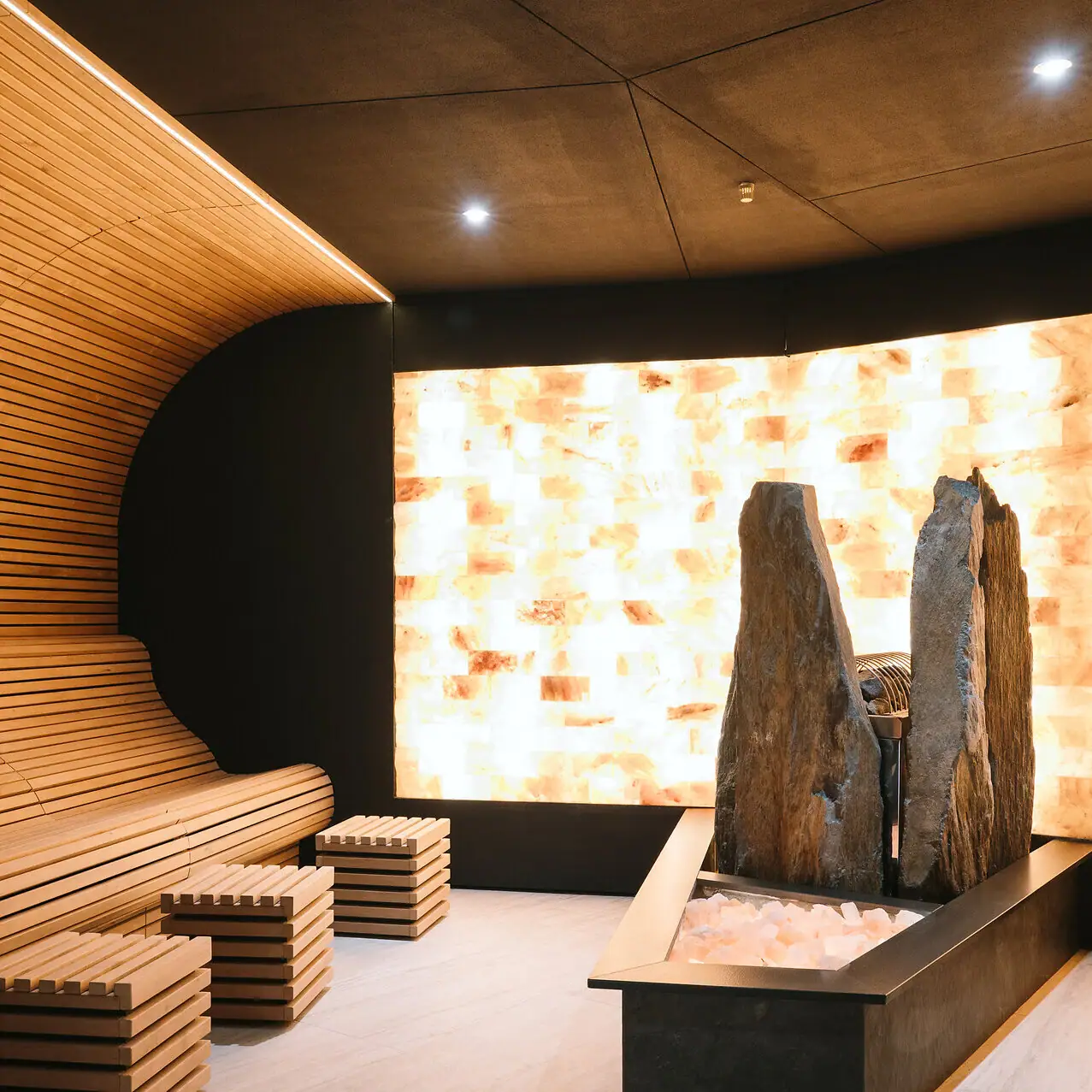 Eine Sauna mit Salzwand sowie mit einer Bank und Salz-Steinen.