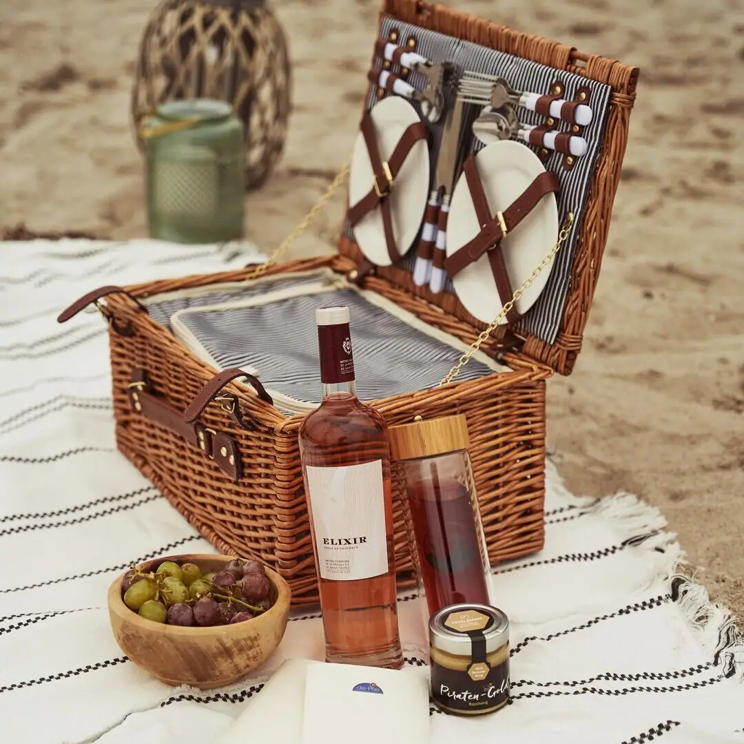 Picknickkorb mit Wein und Früchten auf einer Decke