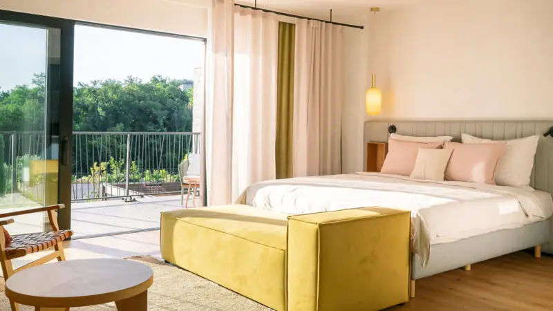 A bedroom featuring a bed and a couch with elegant interior design elements.