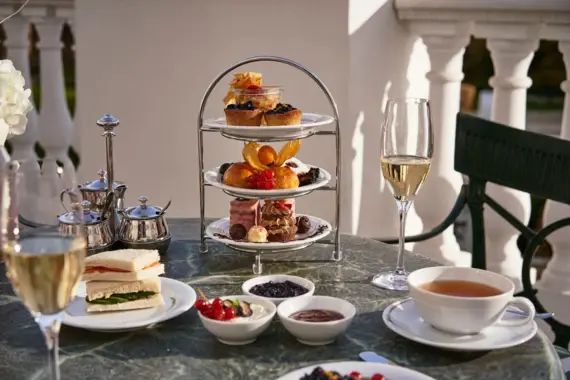 Table with crockery, cutlery and various dishes and drinks.